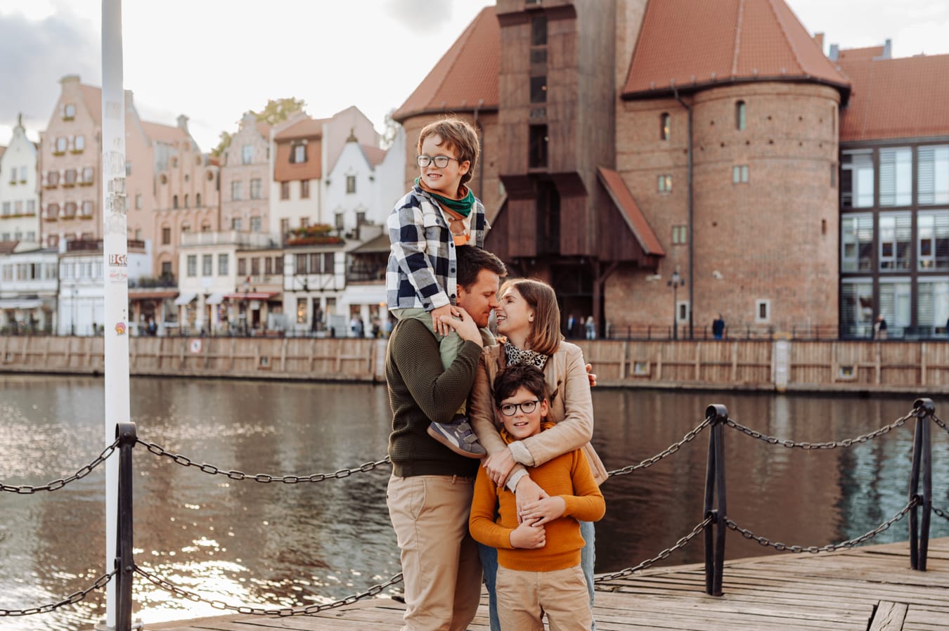 Rodzina z dwoma chłopcami na tle Żurawia i Motławy — miejska sesja rodzinna Gdańsk