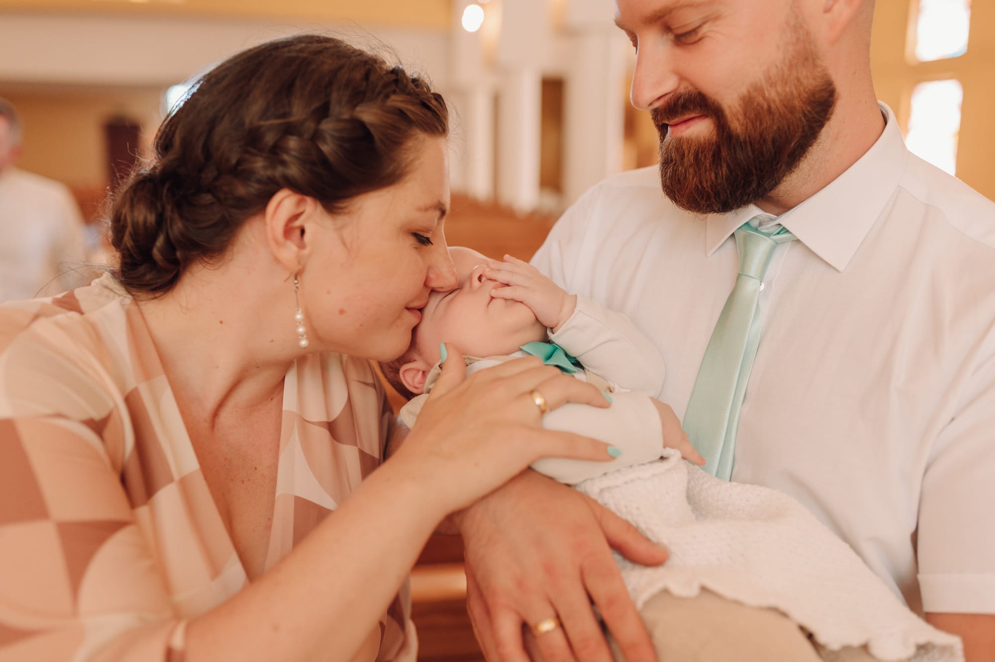 Maluszek przytulany przez rodziców podczas chrzcin — Gdynia