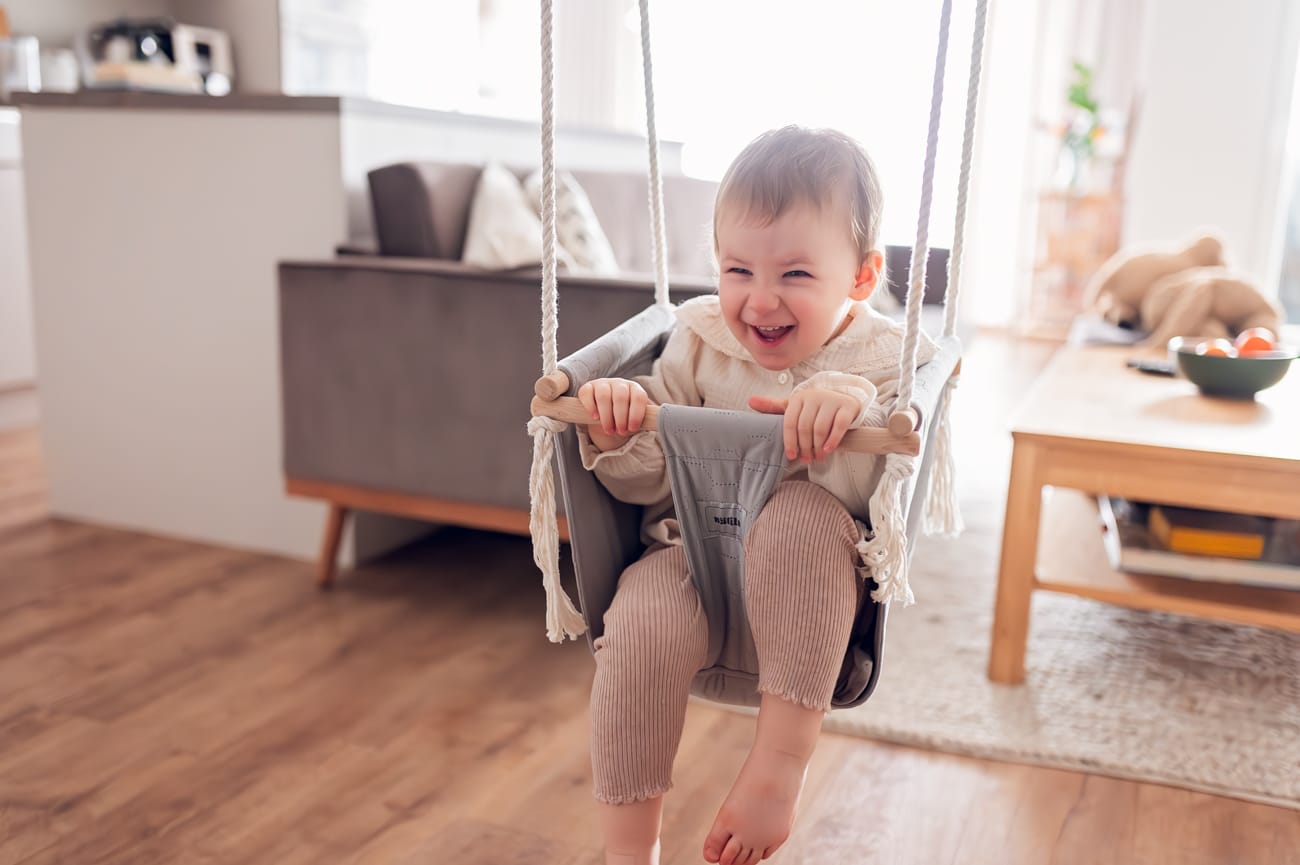 Córka na domowej huśtawce sesja rodzinna w domu
