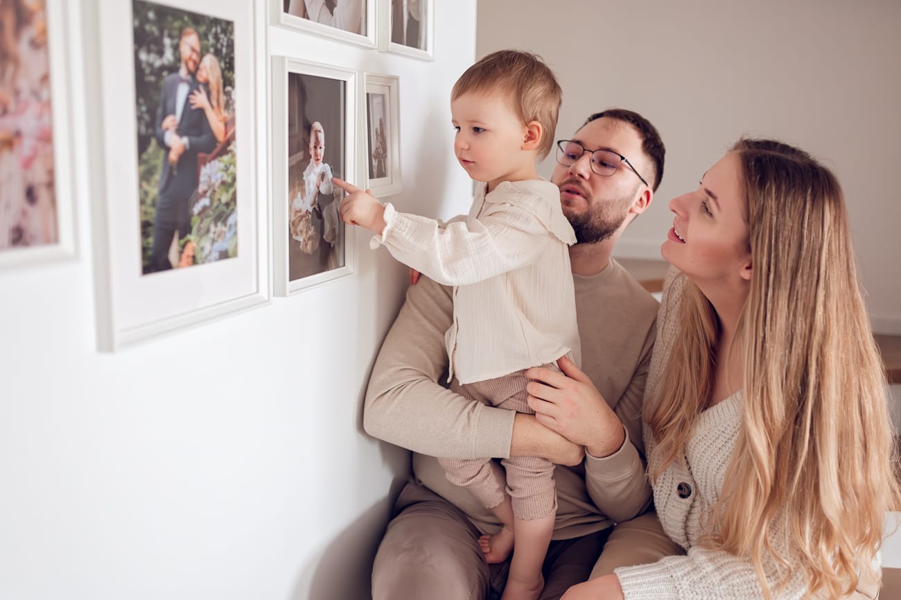 Dziewczynka oglądająca domową galerie zdjęć wiszącą na ścianie. 