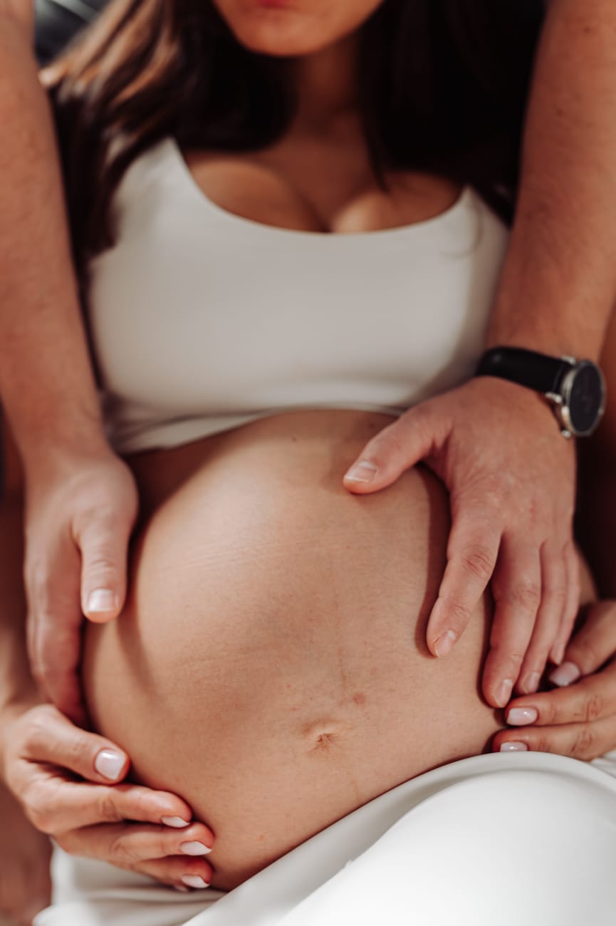 Zbliżenie brzuszka ciążowego podczas domowej sesji ciążowej