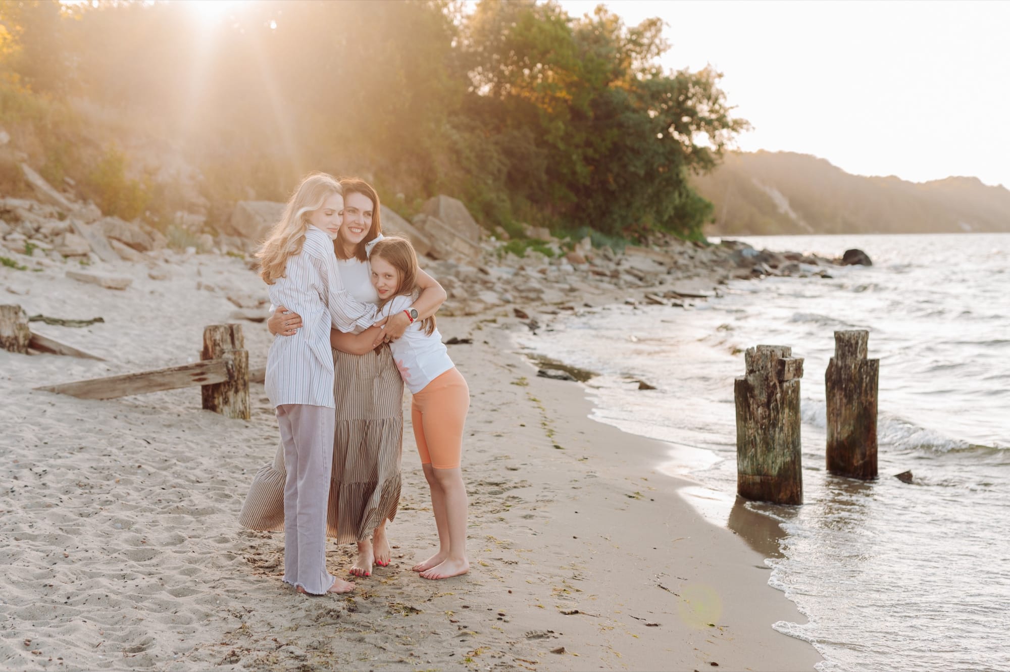 Mama z dwiema nastoletnimi córkami w promieniach zachodzącego słońca — sesja rodzinna Babie Doły