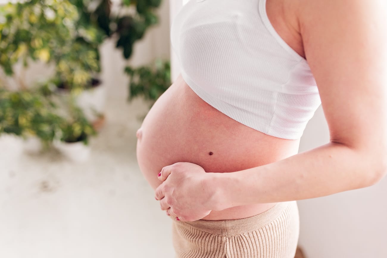 Dłonie na brzuszku sesja ciążowa w studio Gdańsk