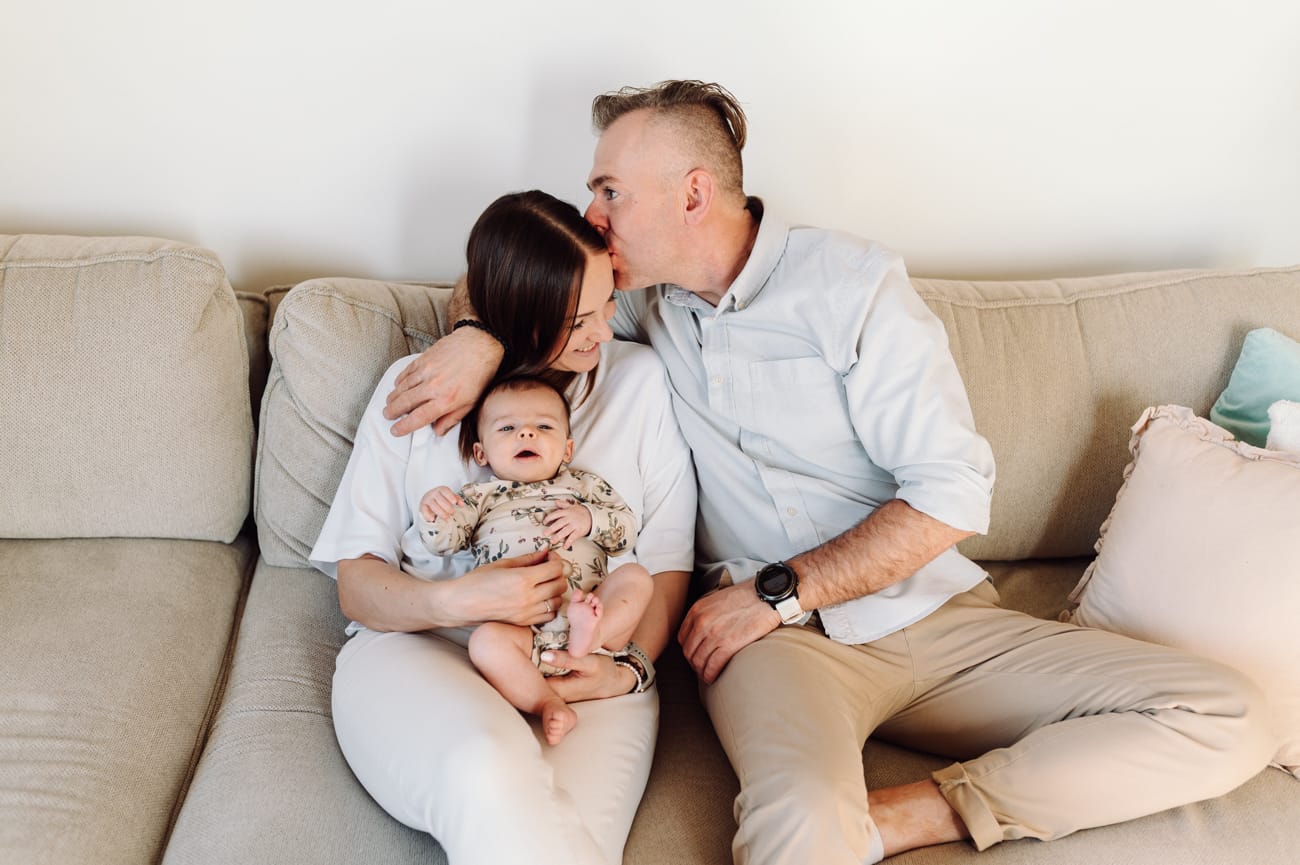 Rodzina z niemowlakiem na kanapie — domowa sesja Gdańsk