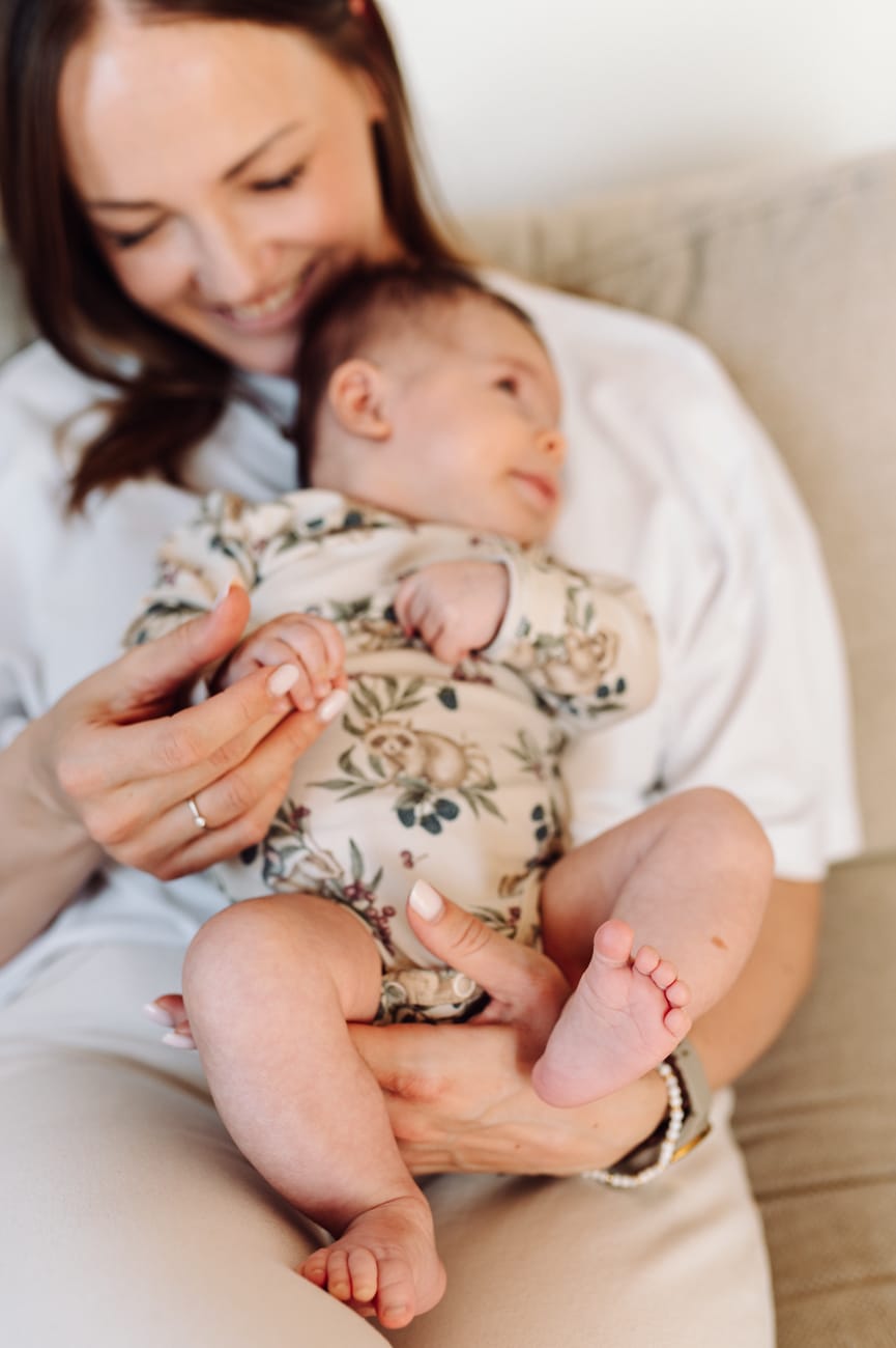 Mama z niemowlakiem na kanapie — naturalna sesja lifestyle Gdańsk