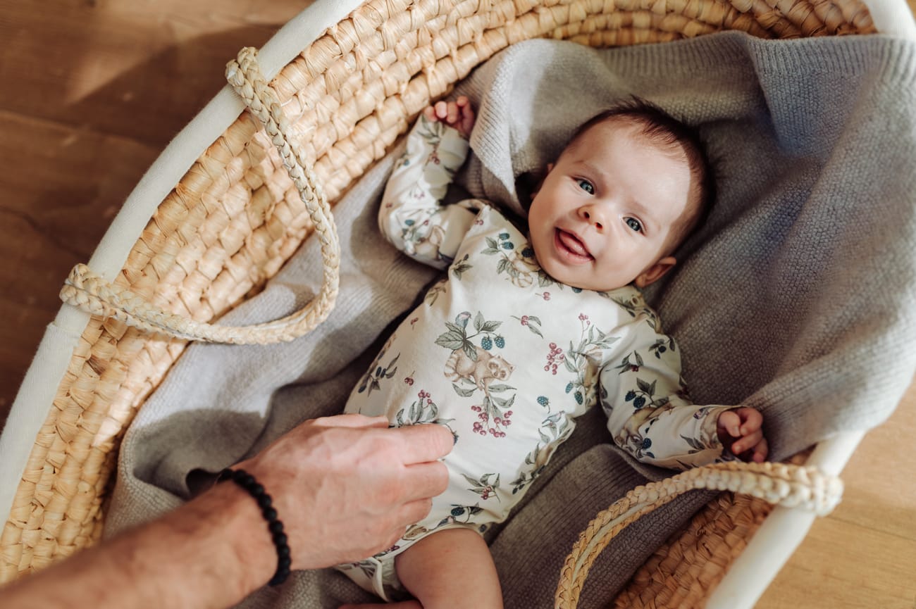 Roześmiane niemowle w koszu Mojżesza naturalna sesja lifestyle Trójmiasto