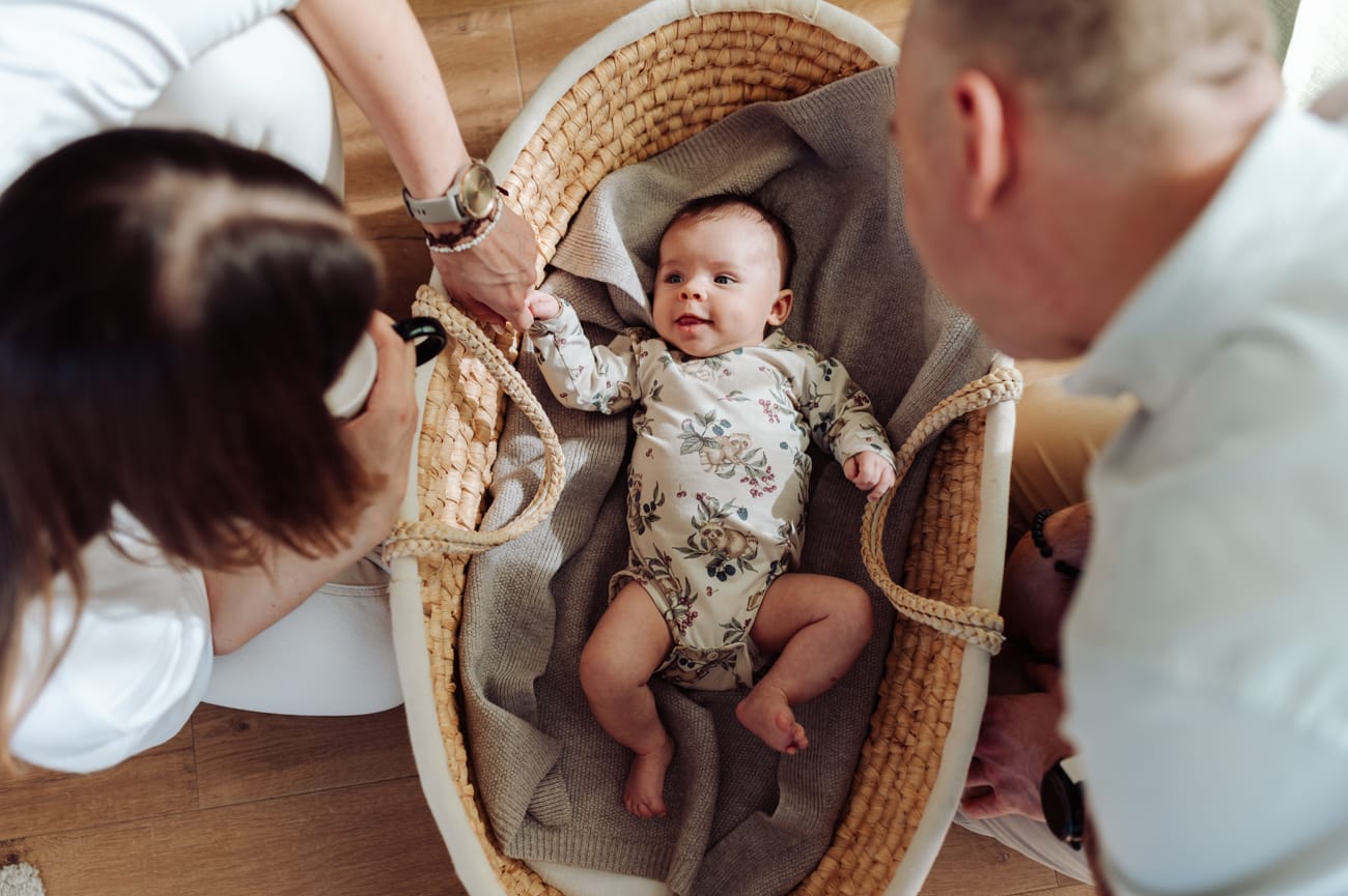 Niemowlę w koszu Mojżesza z rodzicami sesja niemowlęca w domu Trójmiasto