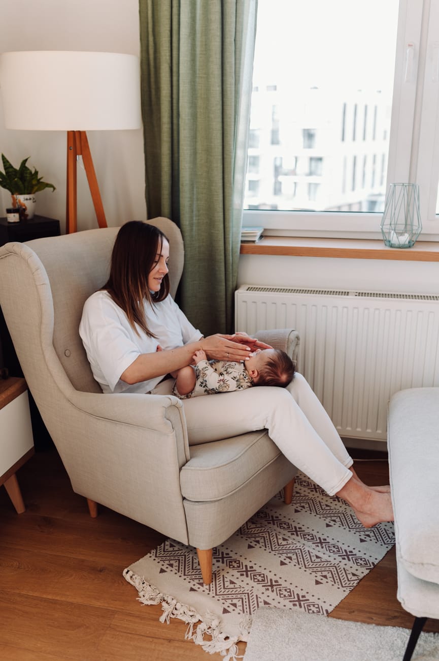 Młoda mama z córeczką na kolanach  - lifestyle sesja niemowlęca Trójmiasto