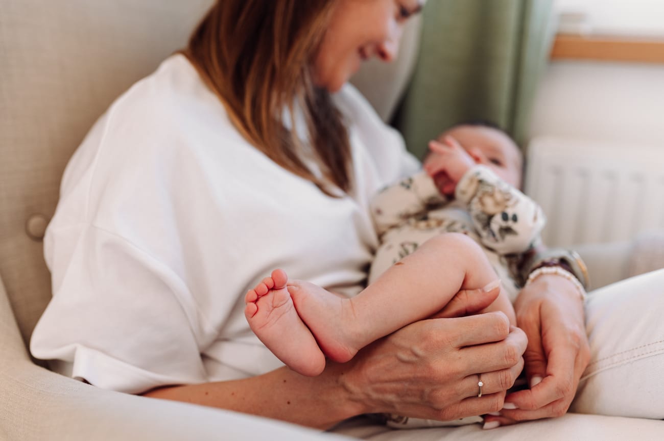 Stópki niemowlaka trzymanego na kolanach mamy -  lifestyle sesja niemowlęca Trójmiasto