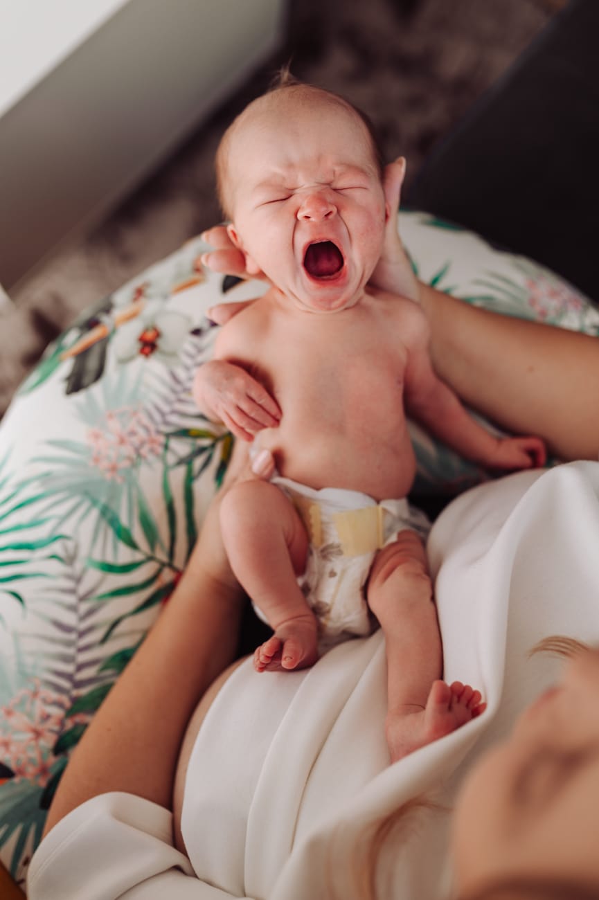 Ziewający noworodek w dłoniach mamy sesja lifestyle Gdynia