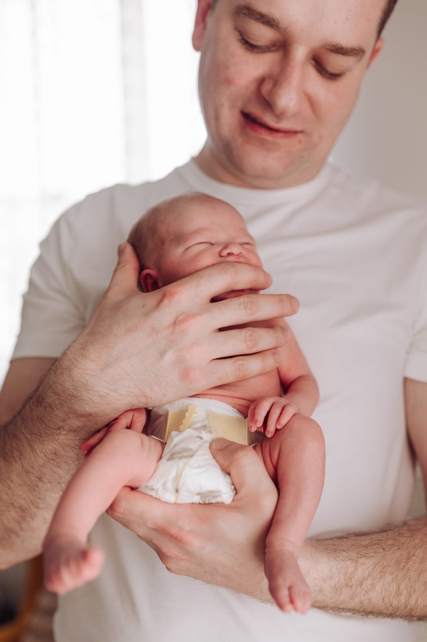 Noworodek na rękach taty jak wygląda sesja w domu