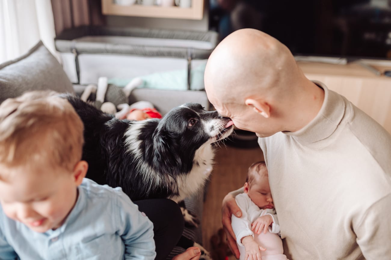 Rodzina z psem który liże po twarzy sesja w domu Gdynia