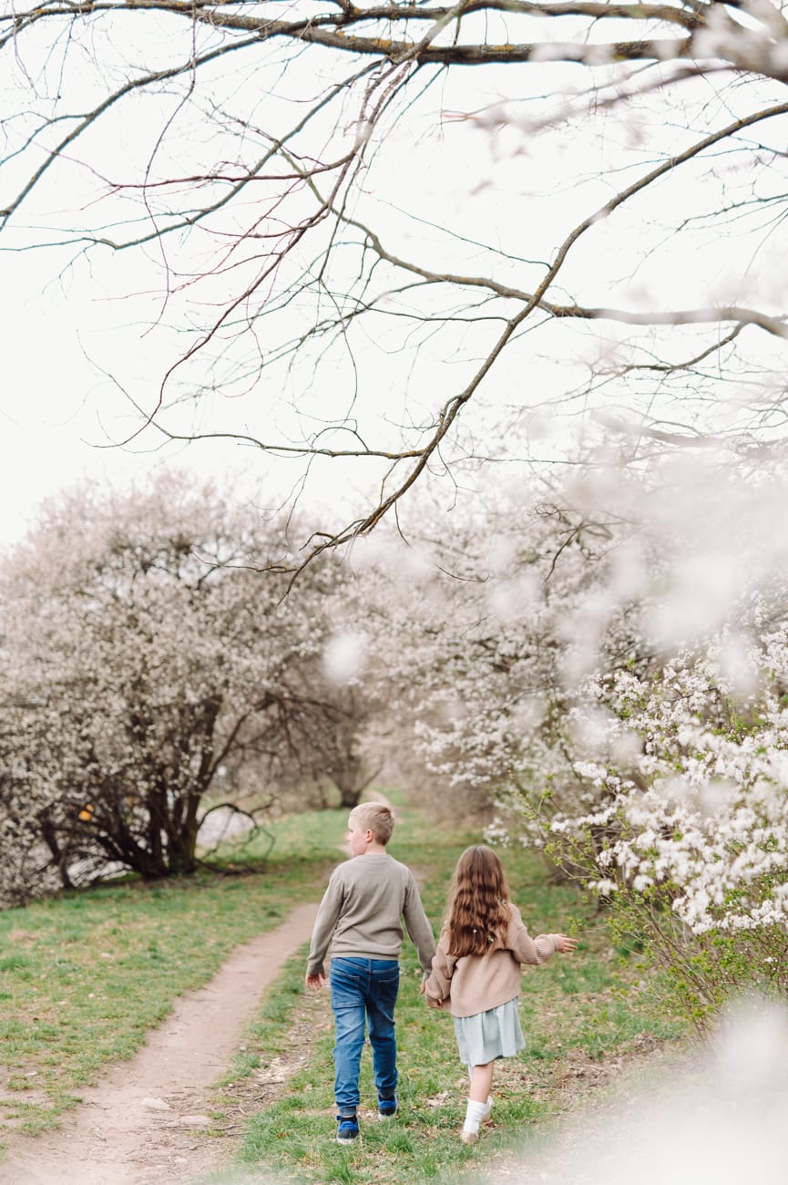 Dzieci idą ukwieconą alejką sesja dziecięca Gdynia