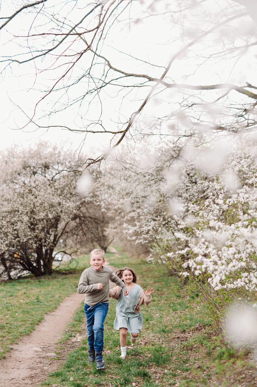 Rodzeństwo biegnie alejką w kwiatach sesja Gdynia