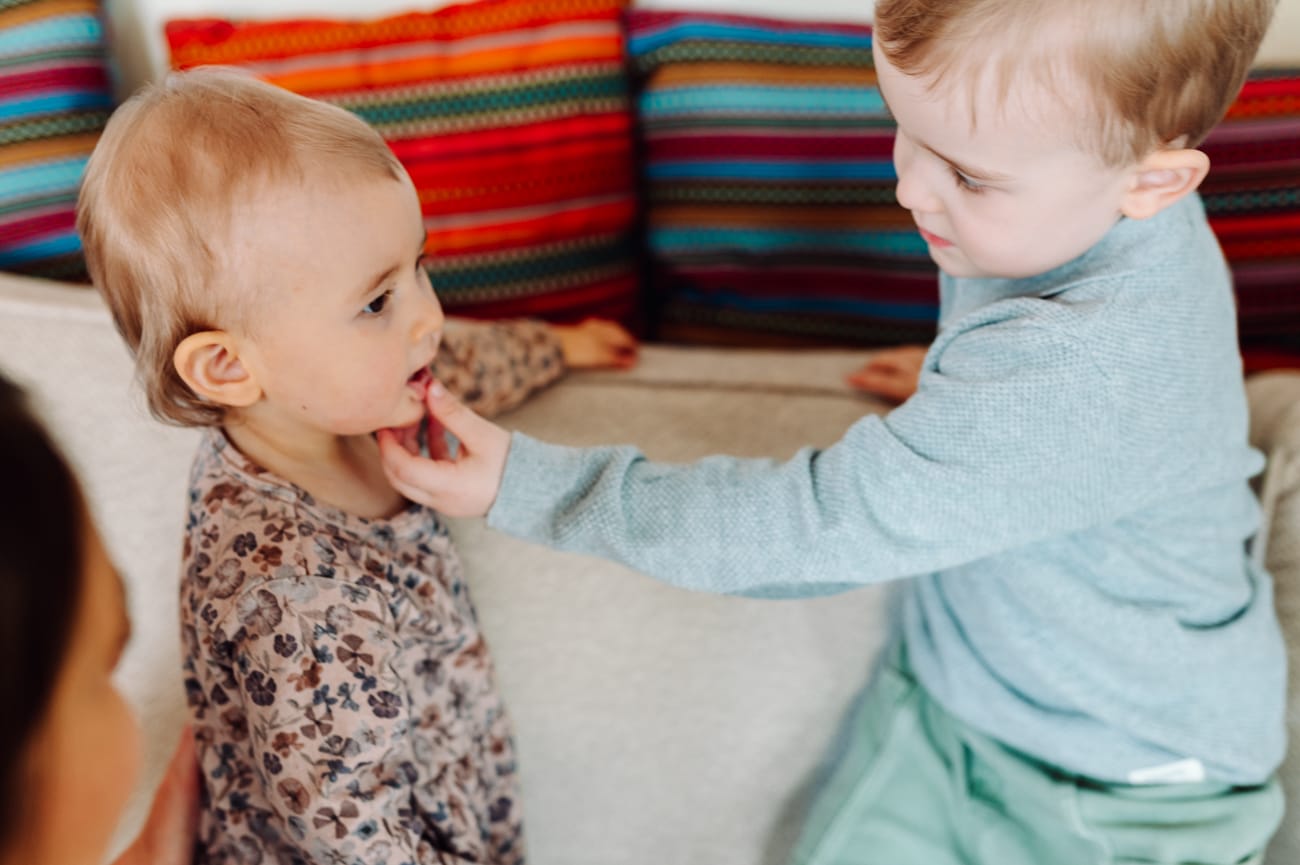 Brat pokazuje ząbki siostry sesja rodzinna w domu