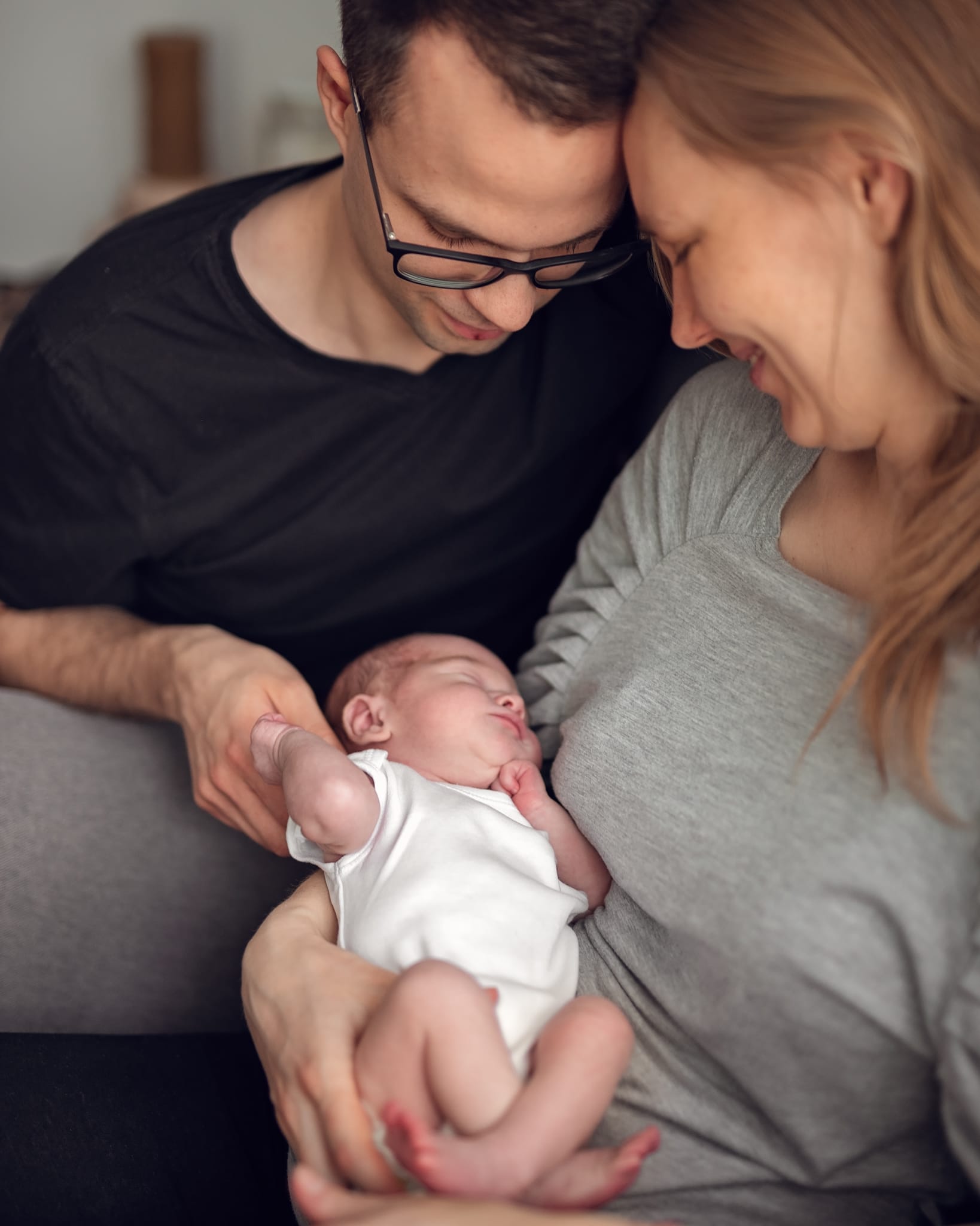 Portret rodziny z noworodkiem jasne wnętrze sesja w domu