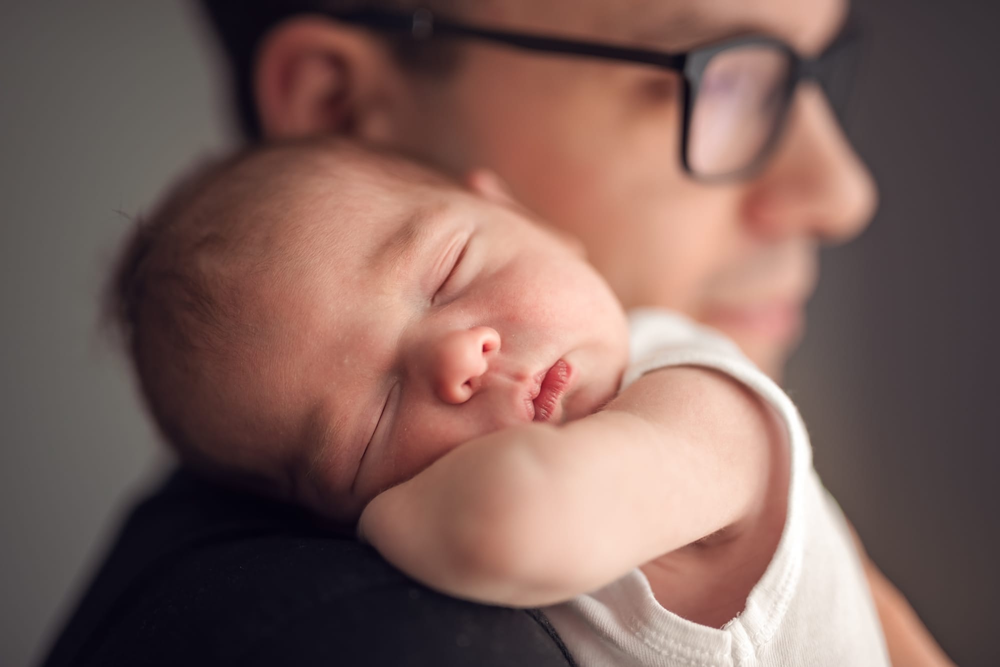 Noworodek w ramionach taty sesja noworodkowa w domu