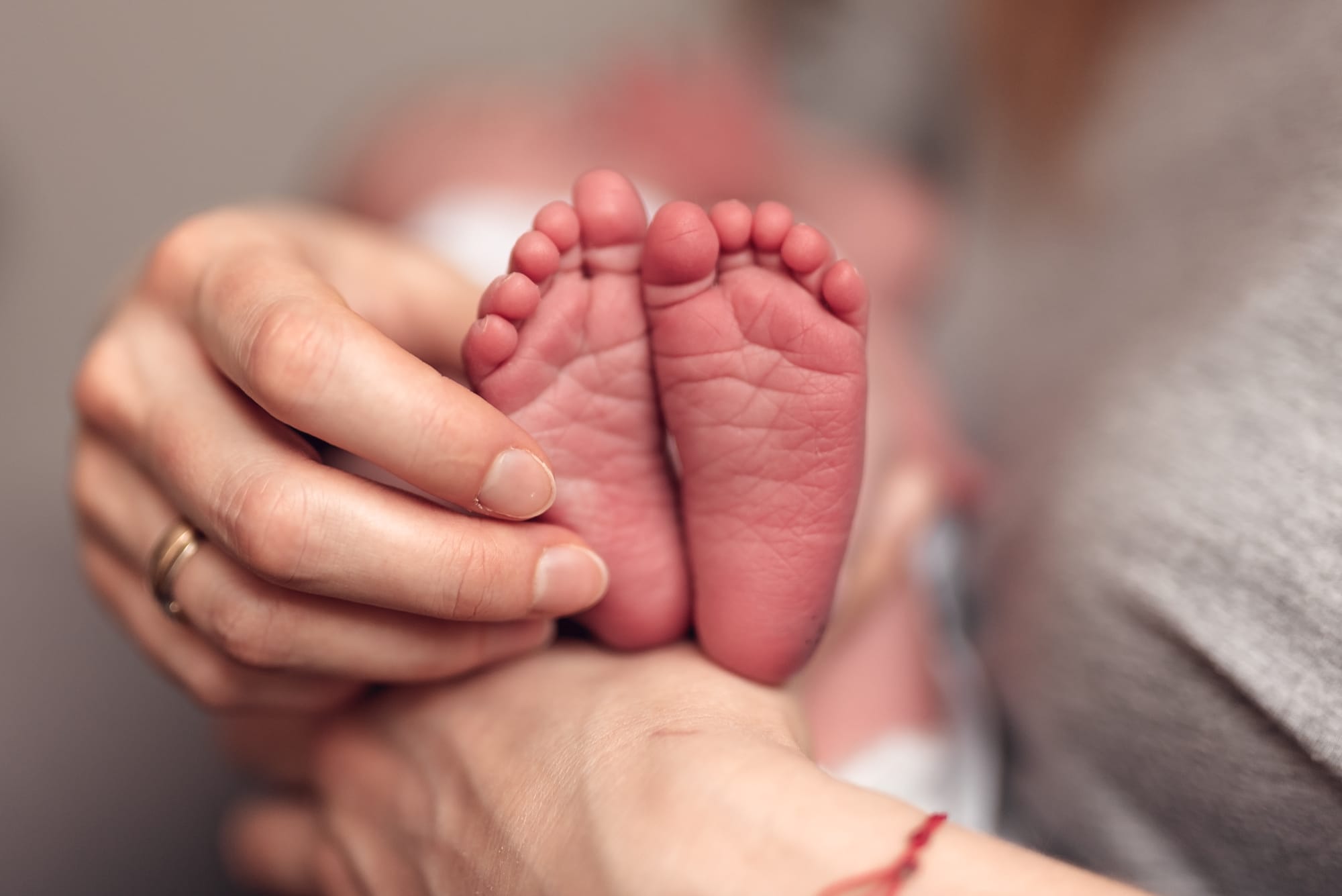 Stópki noworodka w dłoniach mamy sesja w domu