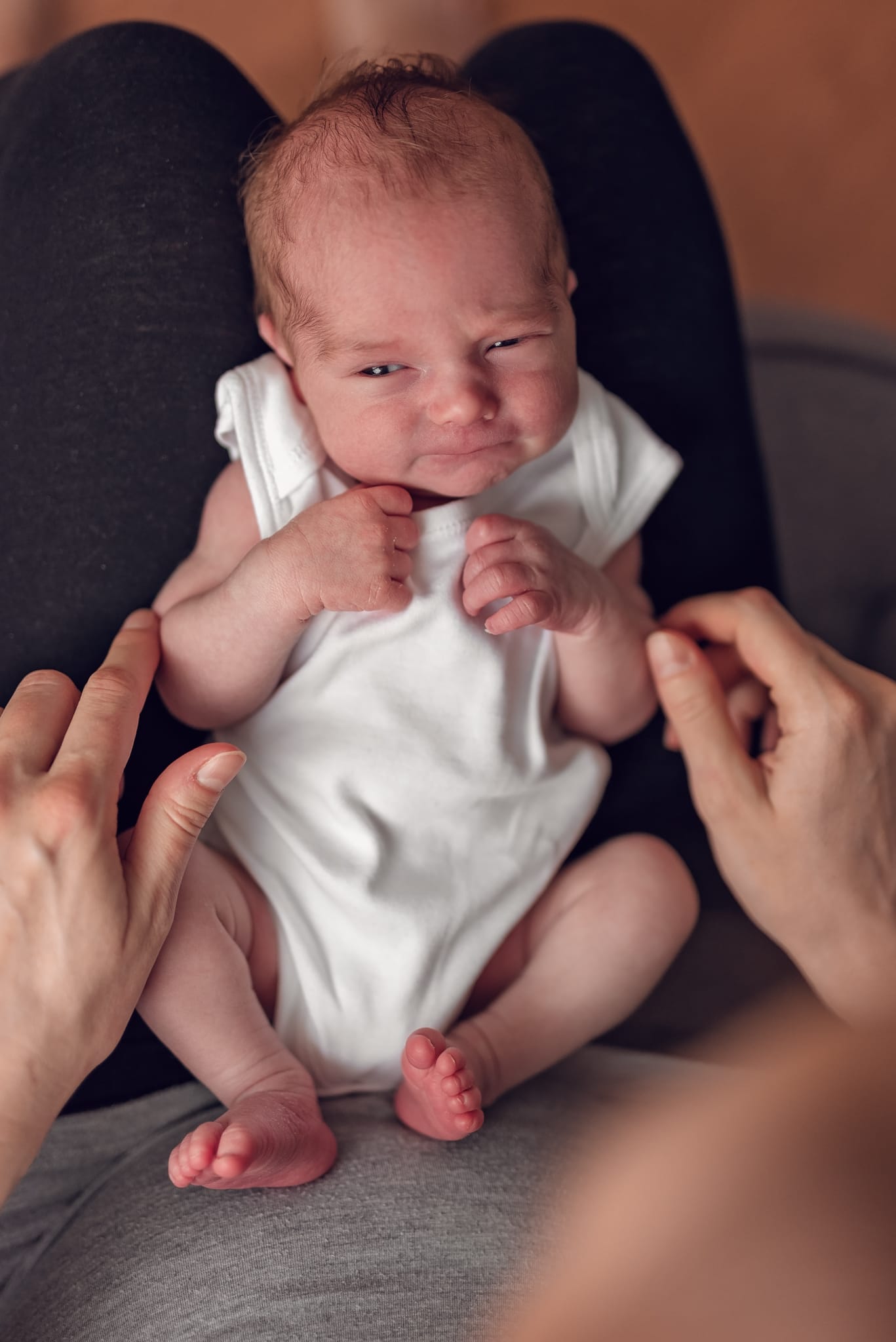 Mama tuli płaczącego noworodka sesja noworodkowa w domu