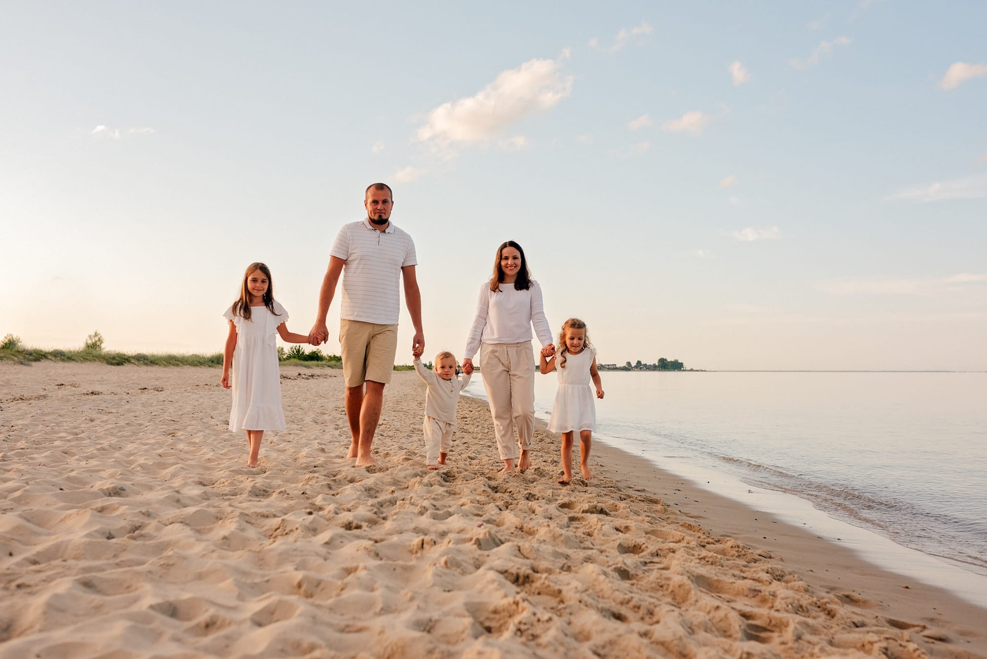 Rodzina spaceruje po plaży spójne stylizacje sesja rodzinna