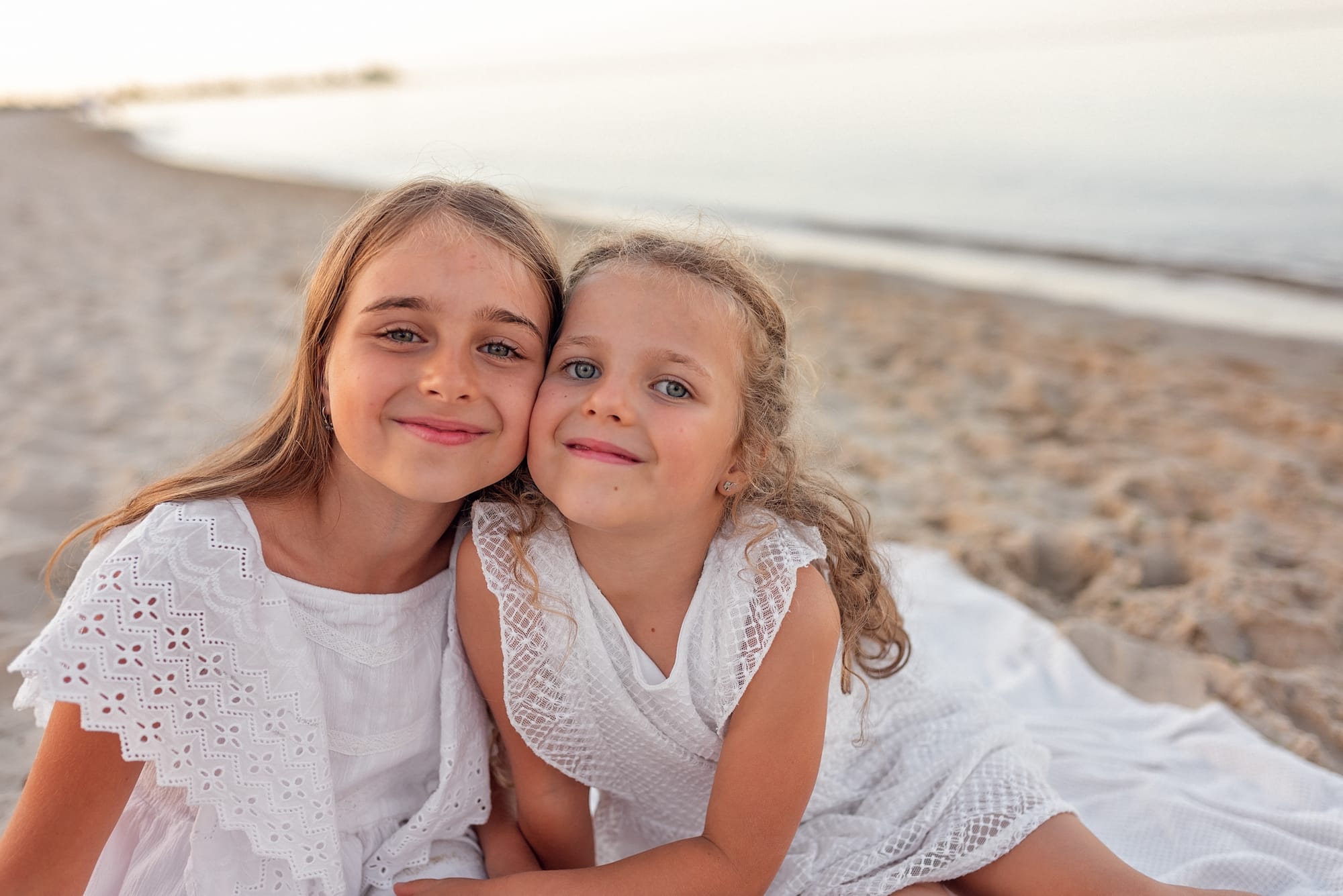 Siostry przytulają się na plaży sesja rodzinna Gdynia