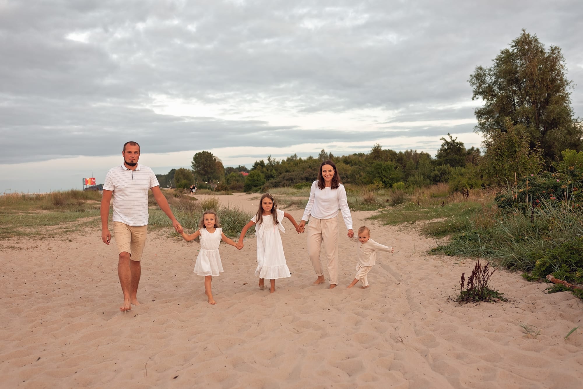Rodzina spaceruje po plaży spójne ubrania sesja Gdynia