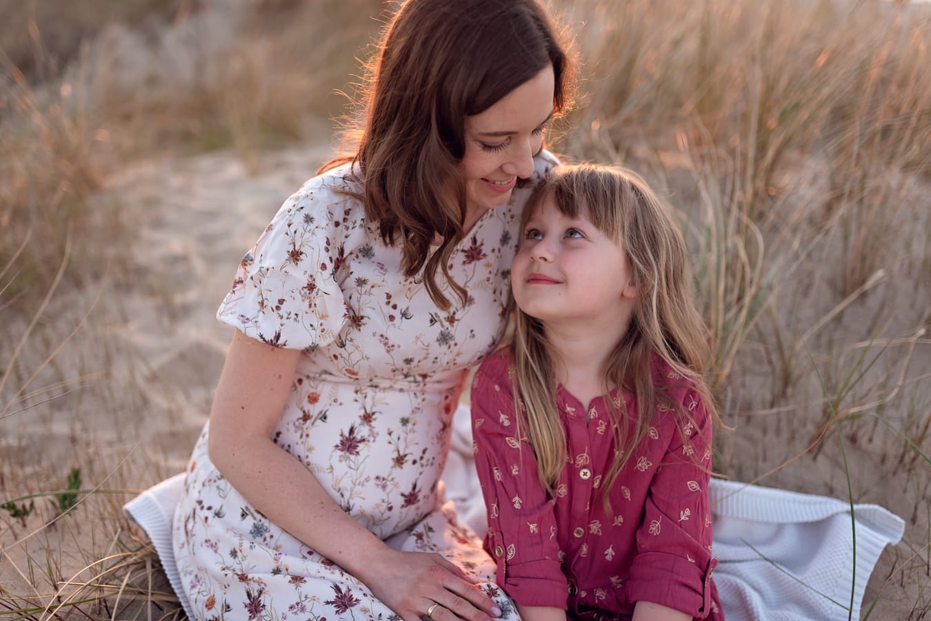 Mama i córka patrzą sobie w oczy sesja ciążowa plaża