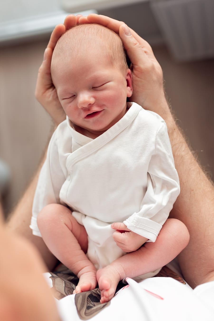 Noworodek uśmiecha się na rękach taty sesja Sopot
