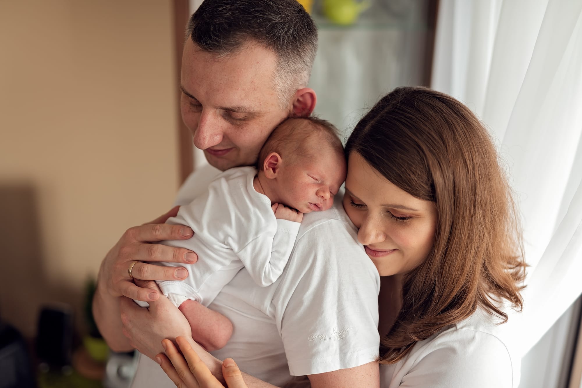 Mama tuli się do taty z noworodkiem sesja w domu