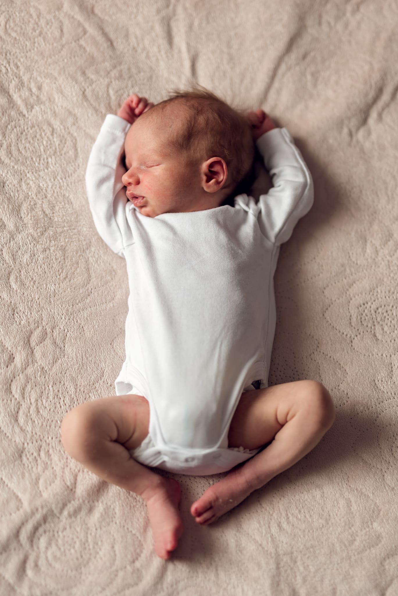 Noworodek na łóżku w co ubrać noworodka na sesję
