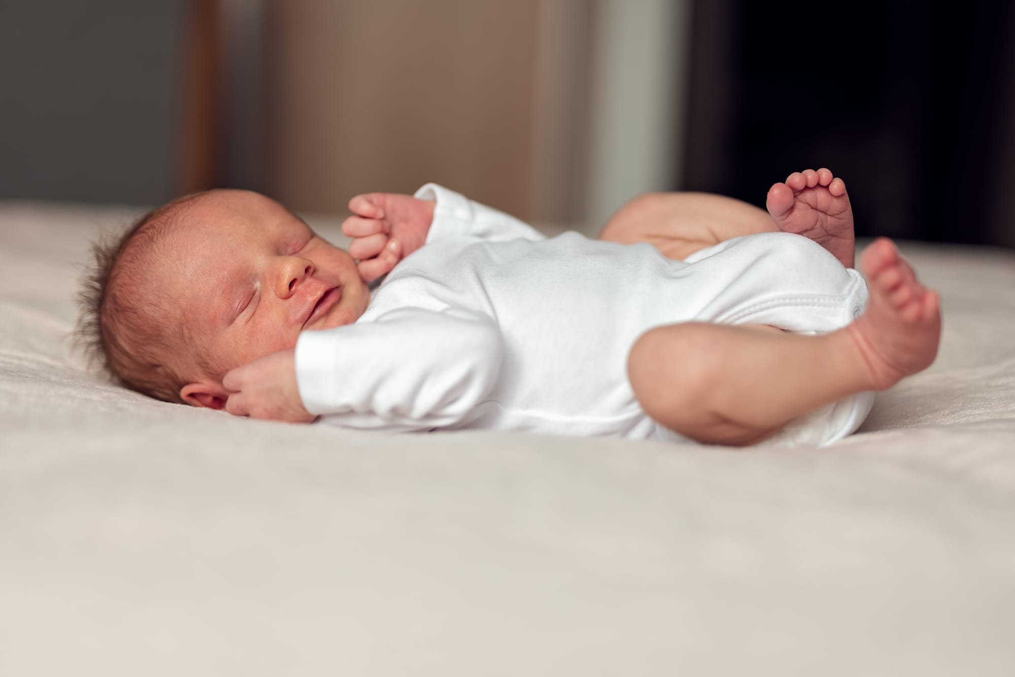 Noworodek w jasnych ubraniach sesja w domu
