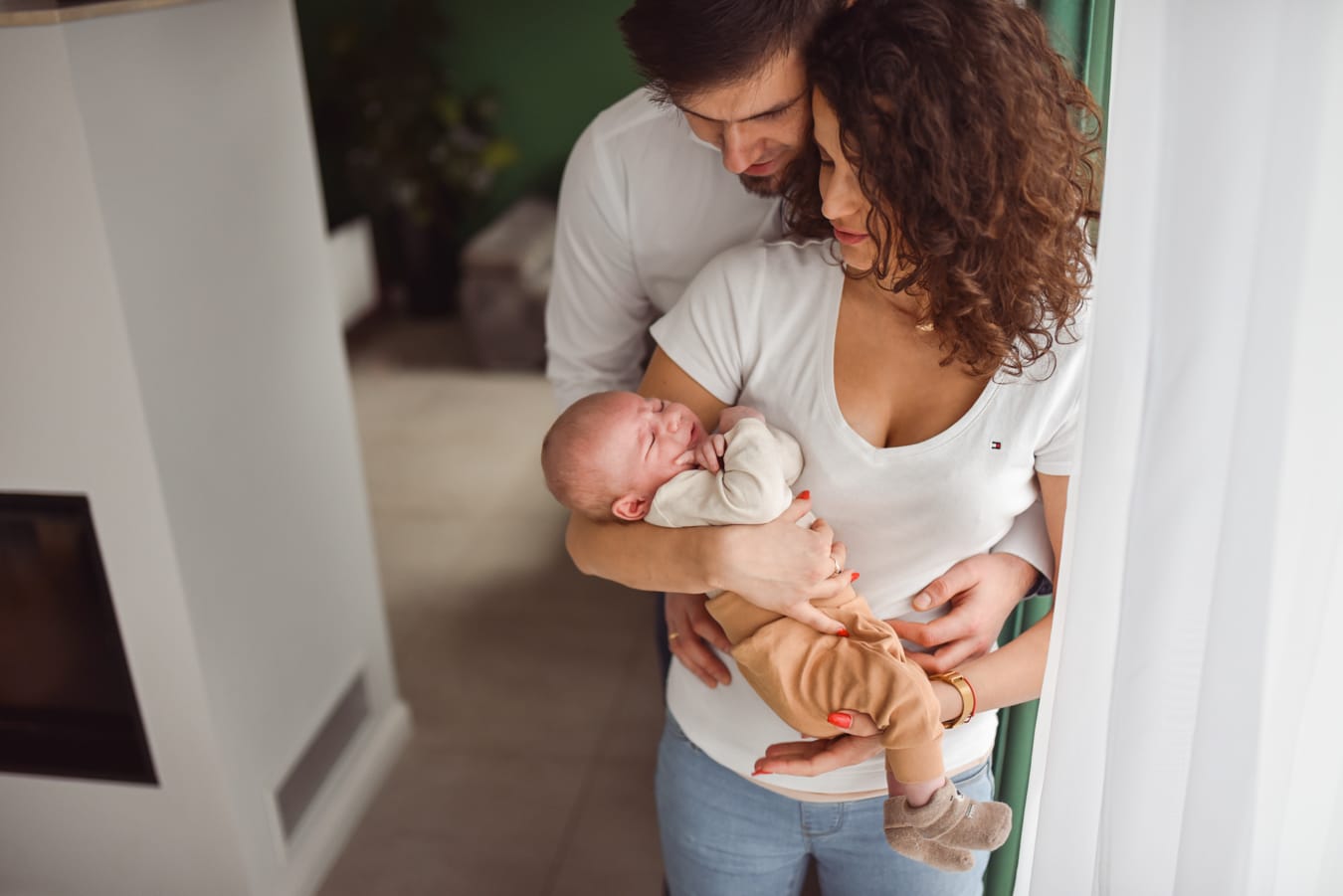 Rodzice patrzą na niemowlę sesja w domu Gdynia