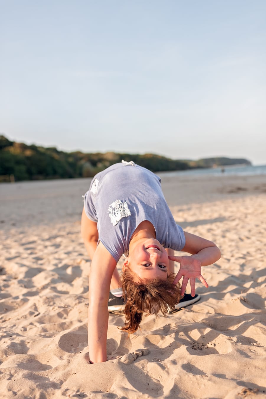 Córka na plaży robi mostek zachód słońca sesja rodzinna Sopot