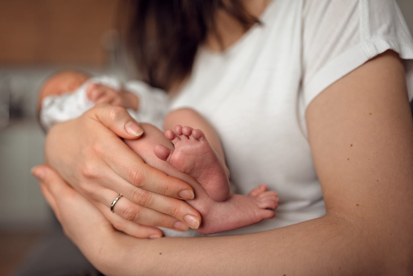Stópki noworodka w dłoniach mamy sesja w domu Gdańsk