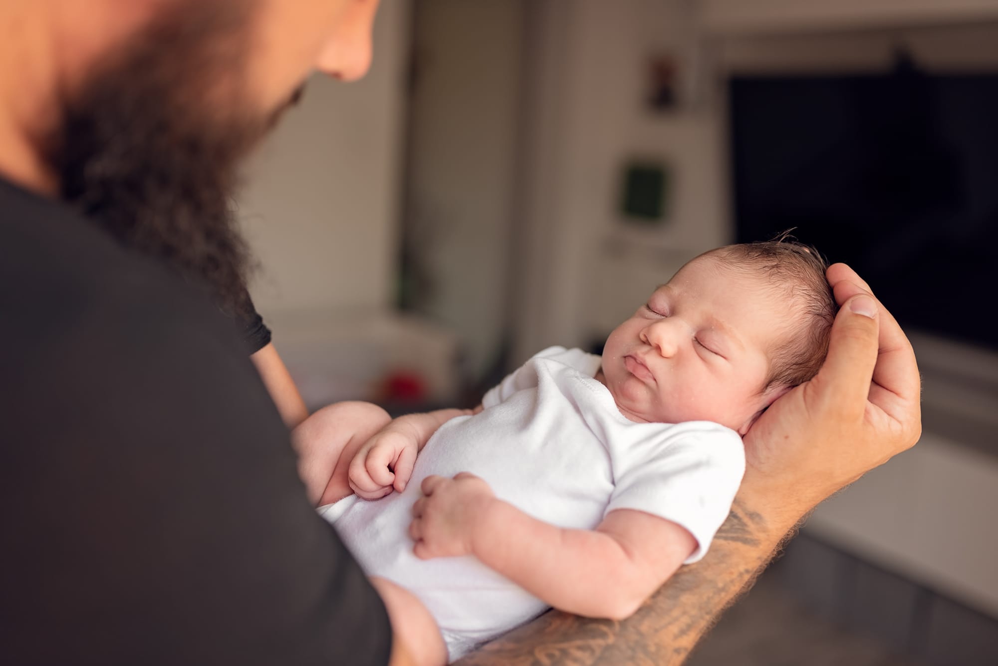 Noworodek na rękach taty fotograf noworodkowy Trójmiasto