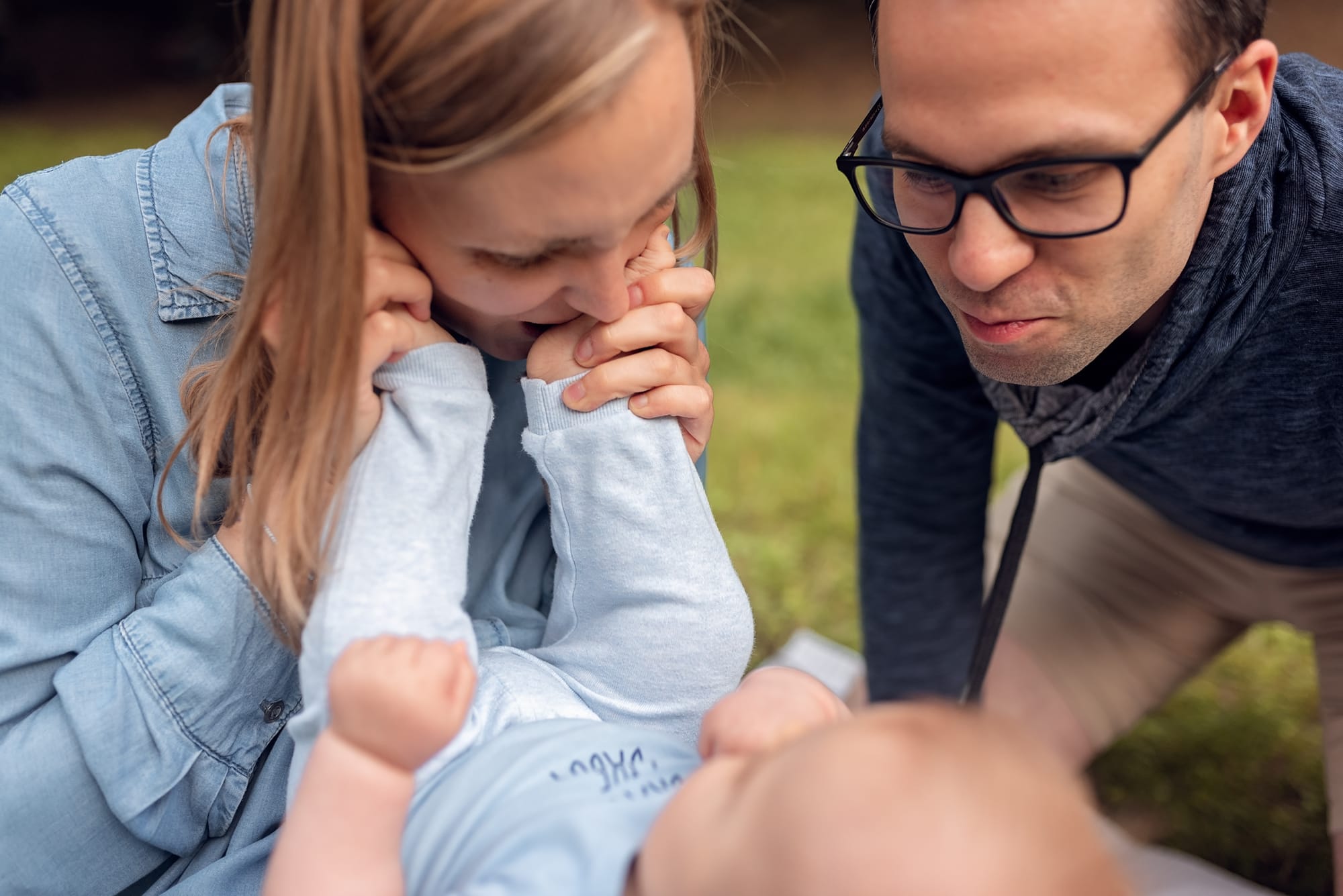 Mama całuje stópki niemowlaka sesja w parku Gdańsk