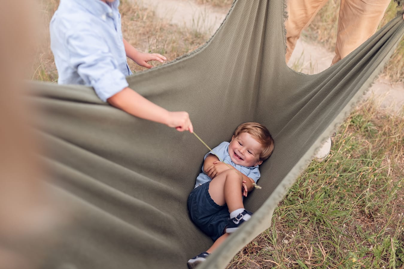 Brat łaskoce brata sesja rodzinna na łące