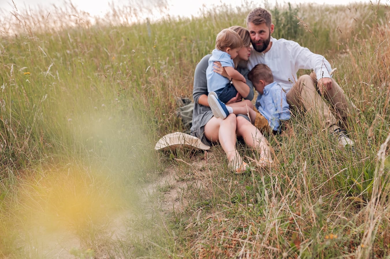 Rodzice z synami na łące sesja rodzinna Gdynia