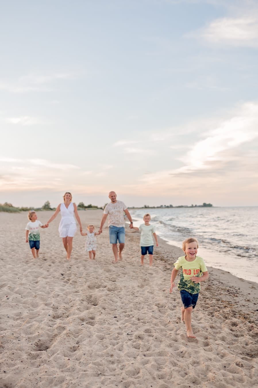 Dzieci biegną po plaży sesja rodziny wielodzietnej