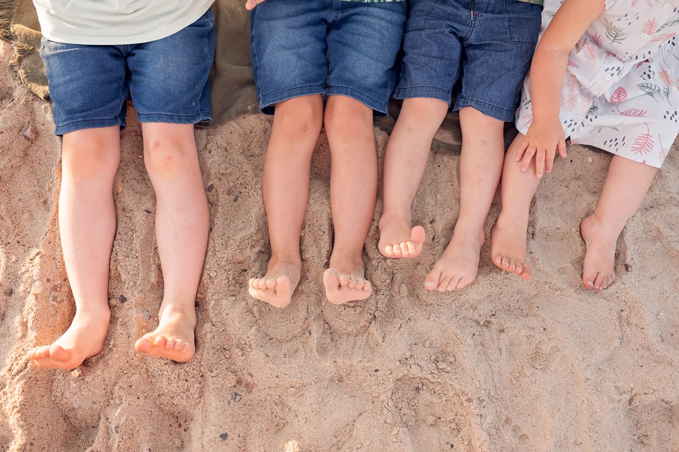 Stopy dzieci na plaży zachód słońca sesja wielodzietna