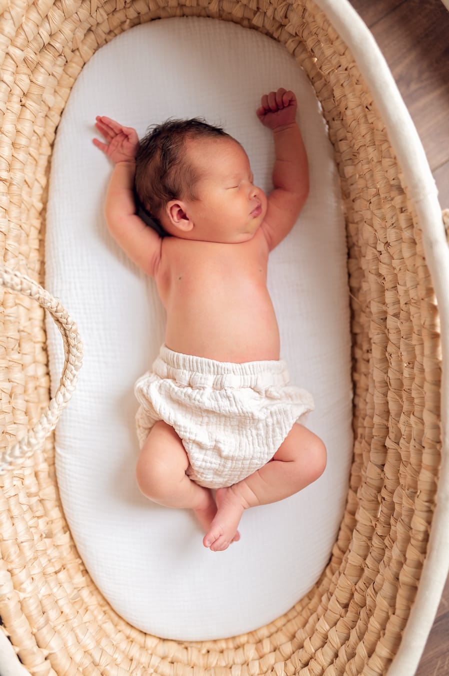 Noworodek śpiący w koszu w domowym zaciszuNoworodek w koszu sesja lifestyle w domu Gdańsk