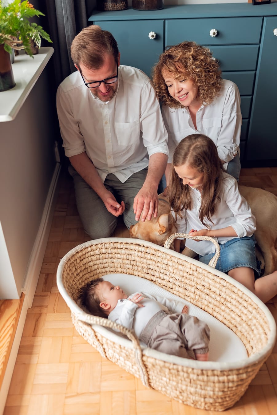 Rodzina z psem nad koszem mojżesza sesja w domu