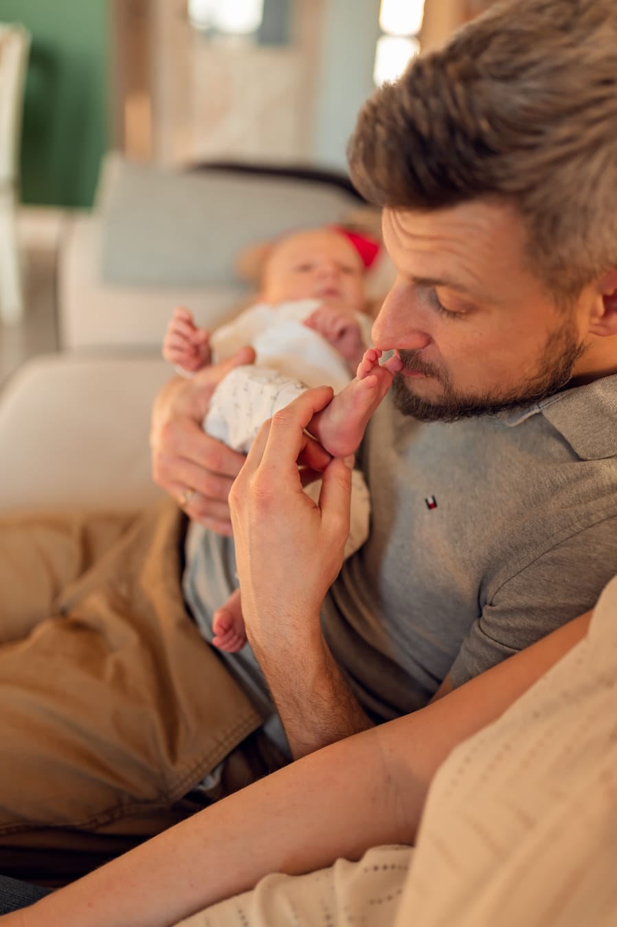 Tata całuje stópkę noworodka sesja w domu Gdańsk