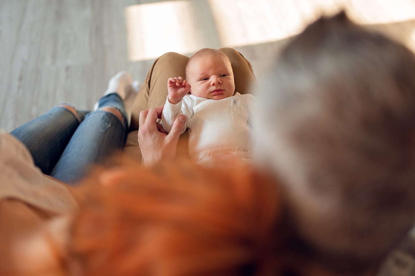 Noworodek na kolanach taty sesja z noworodkiem Gdańsk