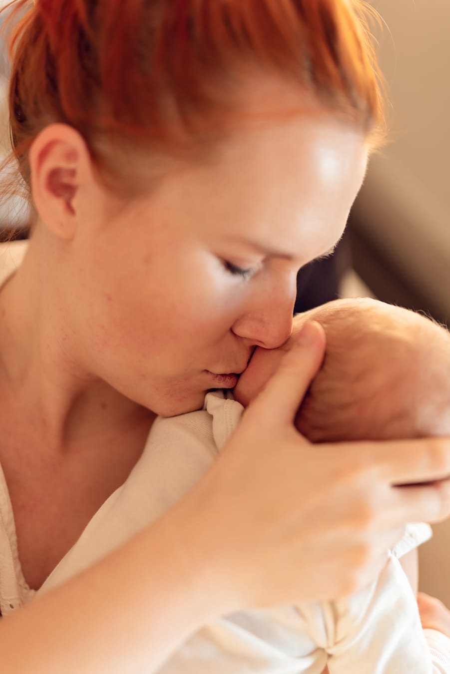 Mama całuje noworodka sesja w domu Gdańsk