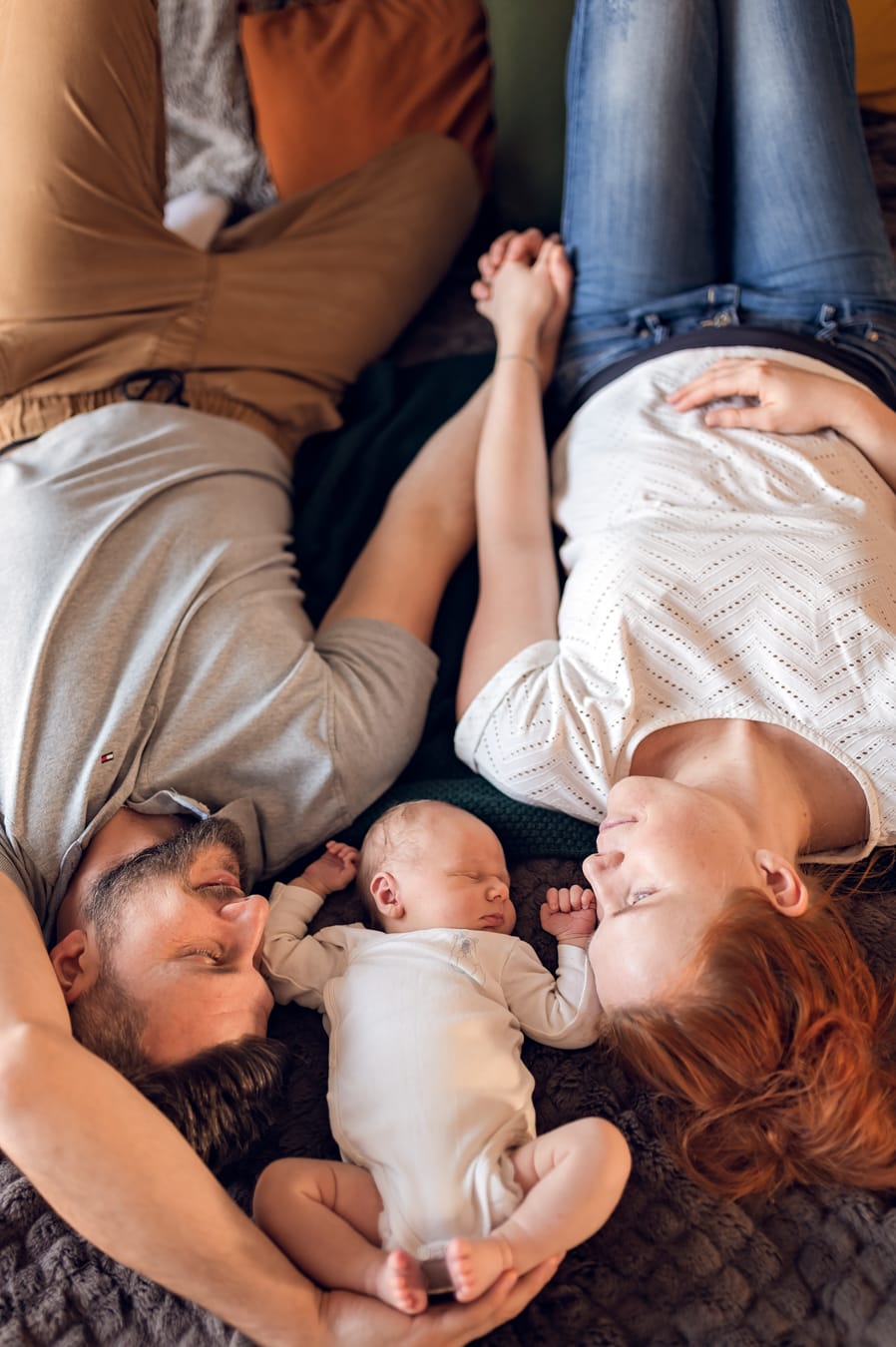 Noworodek śpi między rodzicami sesja z noworodkiem Gdańsk