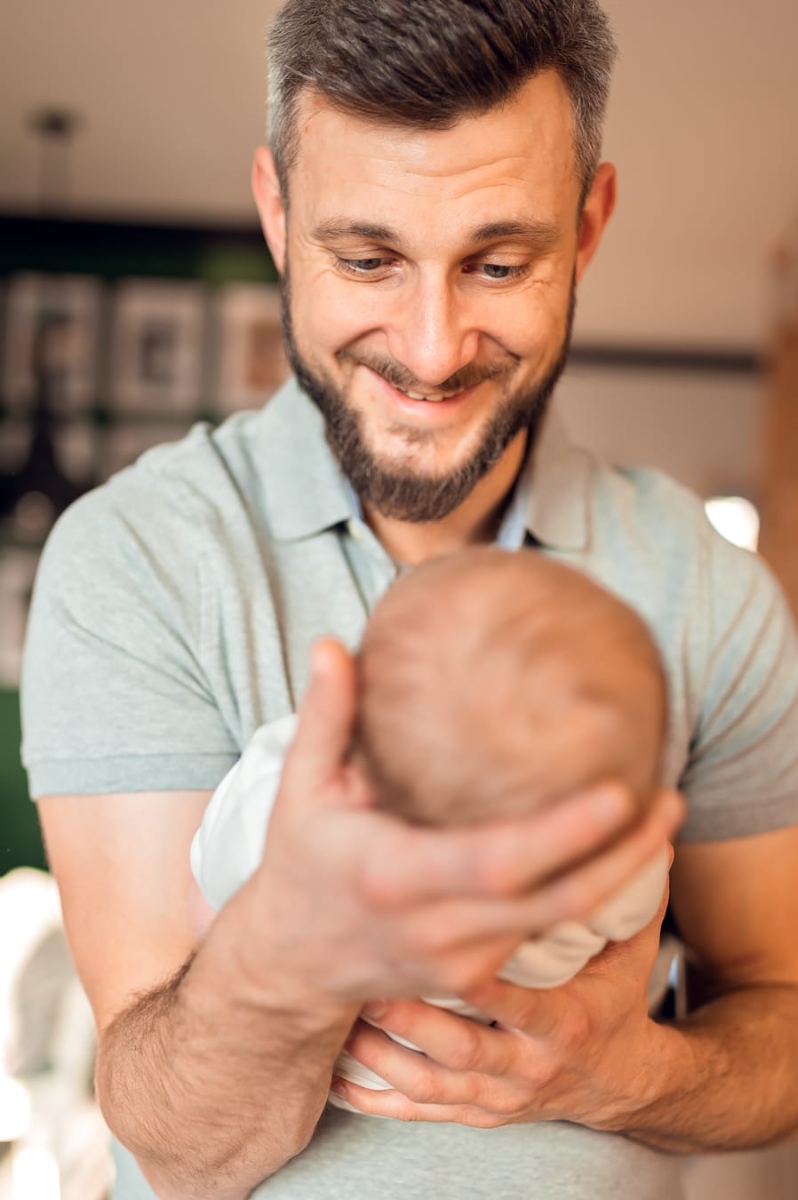 Roześmiany tata z noworodkiem na rękach sesja Gdańsk