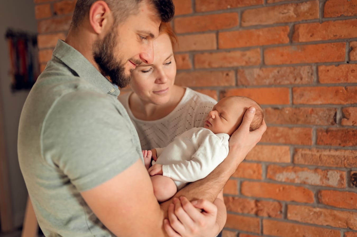Rodzice patrzą na śpiącego noworodka sesja w domu Gdańsk