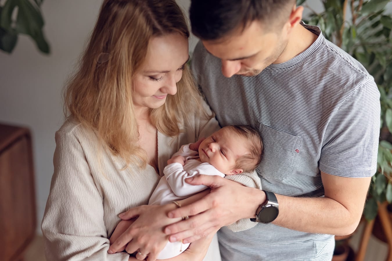 Rodzice patrzą na noworodka sesja noworodkowa w domu Gdańsk