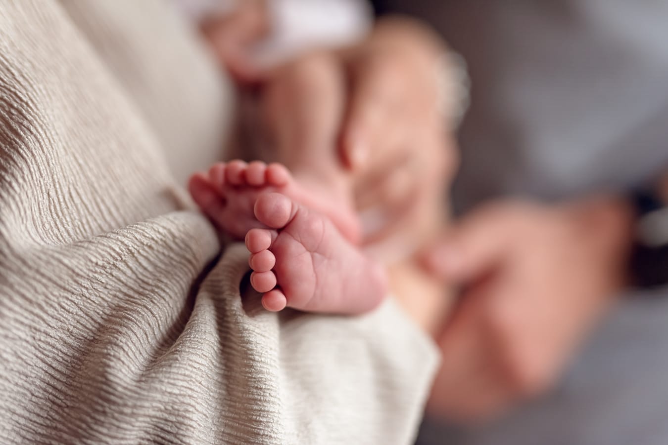 Stópki noworodka w ramionach rodziców sesja w domu Gdańsk